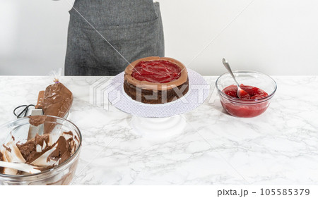 Covering chocolate cake with a crumb layer of chocolate buttercream frosting. Covering chocolate cake with a crumb layer of chocolate buttercream frosting. 105585379