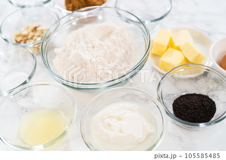 Measured ingredients in glass mixing bowls to bake lemon poppy seed muffins. Measured ingredients in glass mixing bowls to bake lemon poppy seed muffins. 105585485