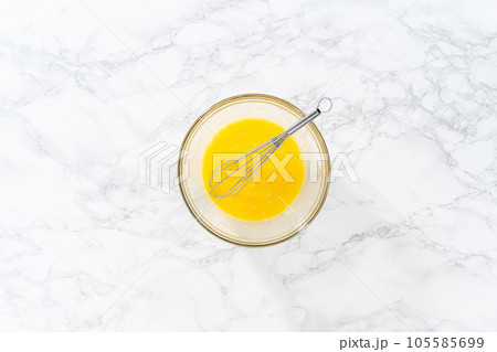 Flat lay. Mixing ingredients in a large glass mixing bowl to bake chocolate peppermint cupcakes. 105585699