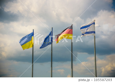 The flag of the European Union and flags of Ukraine, Israel, Germany flutter in the wind in different directions against the blue sky. Bottom side view 105587203