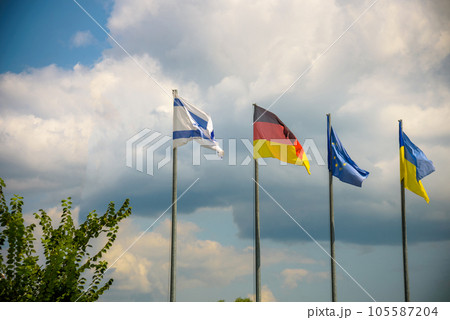 The flag of the European Union and flags of Ukraine, Israel, Germany flutter in the wind in different directions against the blue sky. Bottom side view 105587204