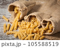 Different dry pasta with flour on grey table 105588519