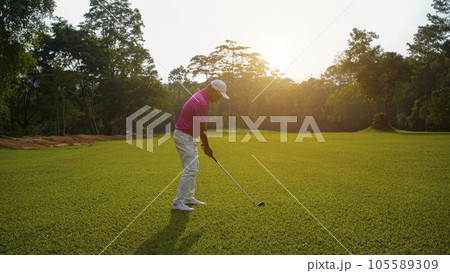 Golfer playing golf in the evening golf course, on sun set evening time. Golfer playing golf in the evening golf course, on sun set evening time. 105589309