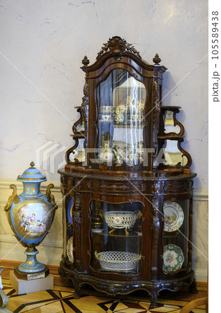 Antique wooden kitchen furniture with dishes and a Chinese vase in interior of 19 century mansion Antique wooden kitchen furniture with dishes and a Chinese vase in interior of 19 century mansion 105589438