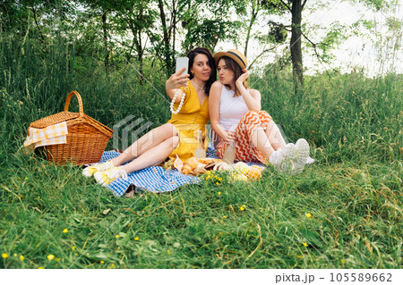 Two friends take selfie on blue blanket for an outdoor picnic 105589662