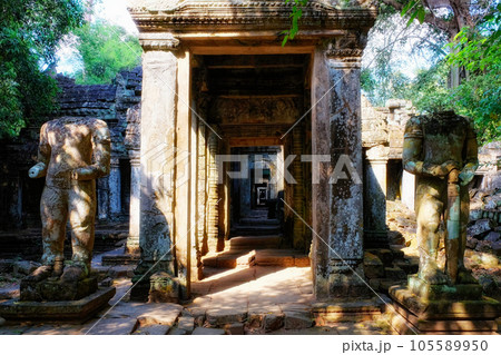 Two ancient damaged sculptures near the entrance to a medieval Buddhist temple, Preah Khan. Two ancient damaged sculptures near the entrance to a medieval Buddhist temple, Preah Khan. 105589950