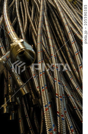 Teflon fitting hoses hanging on the shelf at the sanitary shop Teflon fitting hoses hanging on the shelf at the sanitary shop 105590385