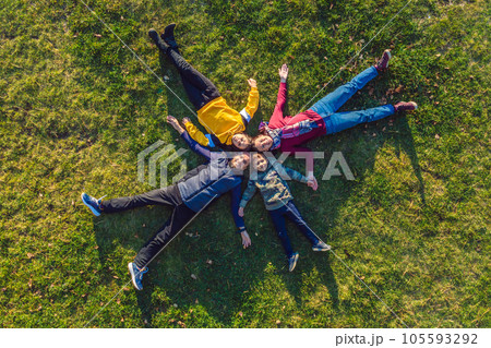 family top view. lying on the grass. sunny day. in green nature together. Aerial view Drone photography 105593292
