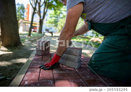 Paving work for laying a new pedestrian path is being done in the summer. 105593295