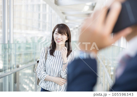 ビジネスイメージ 通路を歩くビジネスウーマンと通話をするビジネスマン手元 ビジネスイメージ 通路を歩くビジネスウーマンと通話をするビジネスマン手元 105596343
