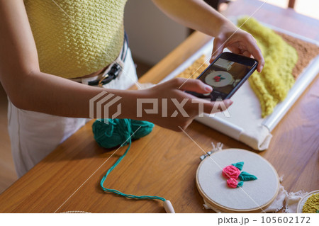 Hand embroidery concept, Women taking photo of embroidery fabric punch diy on canvas in wood hoop Hand embroidery concept, Women taking photo of embroidery fabric punch diy on canvas in wood hoop 105602172