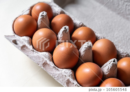 A few brown eggs among the cells of a large cardboard bag, a chicken egg as a valuable nutritious product, a tray for carrying and storing fragile eggs. A full package of eggs, an important food item 105605548