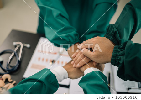 Doctors shaking hands, working together as a team at the hospital. 105606916