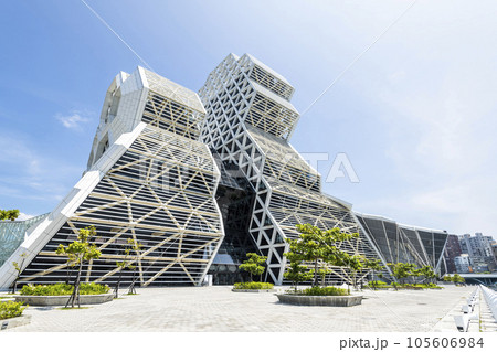 Low angle view of Kaohsiung Music Center in Taiwan. The white hexagonal building structure on the shore of Kaohsiung Port. 105606984