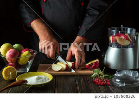 The chef prepares fruit jam from fresh apples. The cook cuts apples for chopping in a blender. Menu or recipe idea for hotel or restaurant The chef prepares fruit jam from fresh apples. The cook cuts apples for chopping in a blender. Menu or recipe idea for hotel or restaurant 105608226
