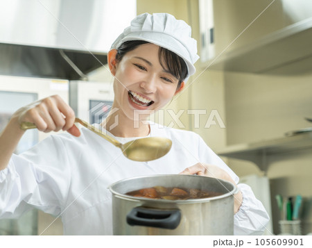調理室でカレーを作る調理服を着た若い女性 105609901