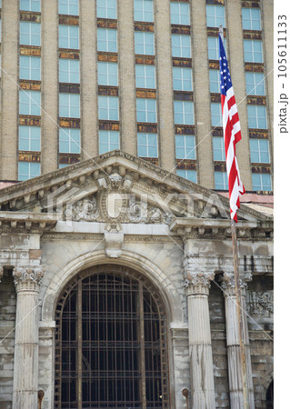 DETROIT, MICHIGAN, UNITED STATES - MAY 5th 2018: A view of the old Michigan Central Station building in Detroit which served as a major railway depot from 1914 - 1988, detailed view with the american DETROIT, MICHIGAN, UNITED STATES - MAY 5th 2018: A view of the old Michigan Central Station building in Detroit which served as a major railway depot from 1914 - 1988, detailed view with the american 105611133