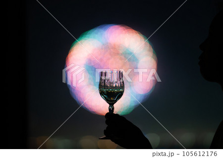 花火を見ながらお酒を飲む女性の手元 105612176