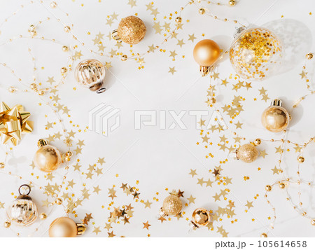 Flat lay of Christmas or New year frame, garland and gold season decoration on white background Flat lay of Christmas or New year frame, garland and gold season decoration on white background 105614658