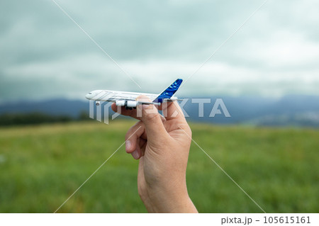 Miniature airplane in hand travel pattern on the top of the mountain 105615161