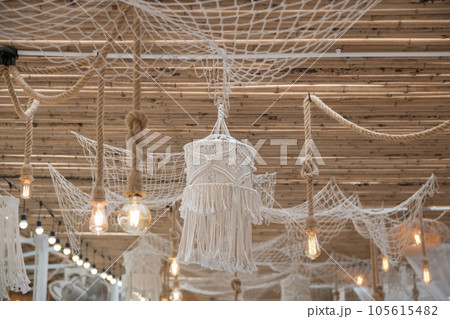 White rope thread net and cage on bamboo ceiling with light bulb 105615482