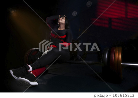 Strong woman doing weights.Sports lifestyle Beautiful fitness woman lifting dumbbells . Fitness sporty woman showing her well trained body. A beautiful girl's body with rippling muscles from strength 105615512