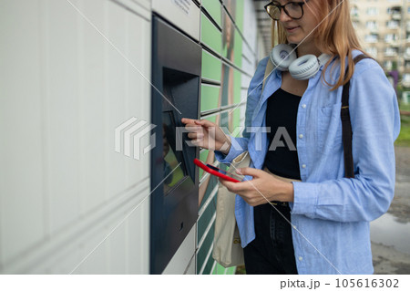 Woman client using automated self service post terminal machine or locker. Mail shipping concept Woman client using automated self service post terminal machine or locker. Mail shipping concept 105616302