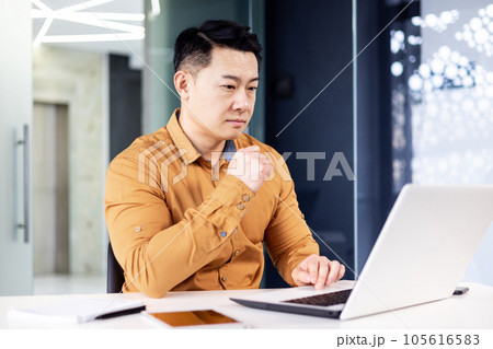 Thinking serious asian businessman working inside office at workplace, man looking concentrated at laptop screen, financier investor reading traders market. Thinking serious asian businessman working inside office at workplace, man looking concentrated at laptop screen, financier investor reading traders market. 105616583