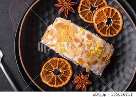 Delicious, fresh, sweet meringue roll with cream, almond chips, nuts and berries Delicious, fresh, sweet meringue roll with cream, almond chips, nuts and berries 105616811