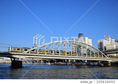 スカイツリーを背景に隅田川を渡る総武線普通電車 105619203