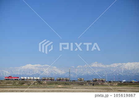 立山連峰を背景に走る高山本線の貨物列車 105619867