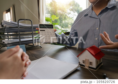 Real estate agent talked about the terms of the home purchase agreement and asked the customer to sign the documents to make the contract legally, Home sales and home insurance concept Real estate agent talked about the terms of the home purchase agreement and asked the customer to sign the documents to make the contract legally, Home sales and home insurance concept 105620726
