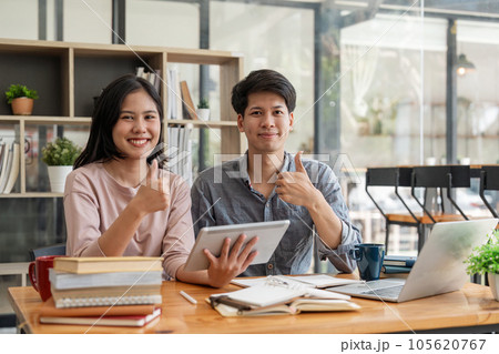 Happy smiling students looking at camera while preparing for exams by reading books at college campus concept of knowledge, education and competition 105620767