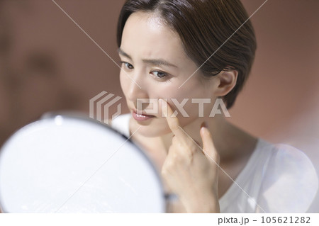 肌トラブルのお手入れをする憂鬱な表情の若い女性 105621282