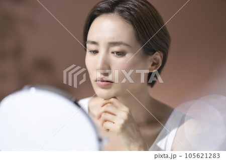 肌トラブルのお手入れをする憂鬱な表情の若い女性 105621283