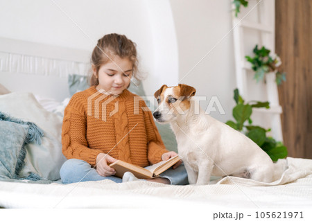 Happy mom and daughter play with their adorable wired Jack Russell Terrier 105621971