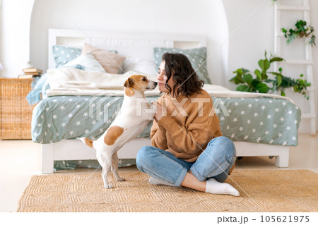Happy mom and daughter play with their adorable wired Jack Russell Terrier Happy mom and daughter play with their adorable wired Jack Russell Terrier 105621975