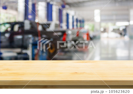 Empty wood table top with car service centre auto repair workshop blurred background Empty wood table top with car service centre auto repair workshop blurred background 105623620