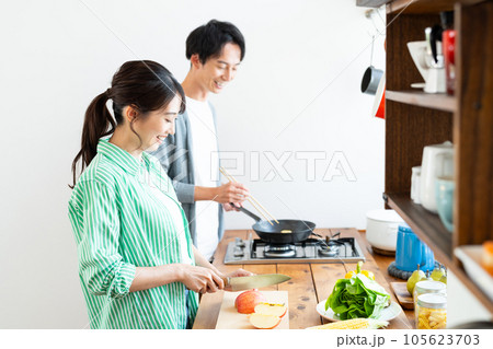 キッチンで料理する若い夫婦 105623703
