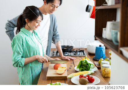 キッチンで料理する若い夫婦 105623708