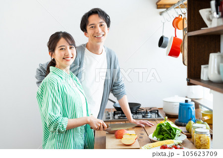 キッチンで料理する若い夫婦 105623709