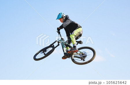 Bicycle, man and jump in blue sky for competition, freedom and adventure with mockup space. Athlete, sports and bike in air for action, cardio race and courage for stunt performance, power or contest 105625642