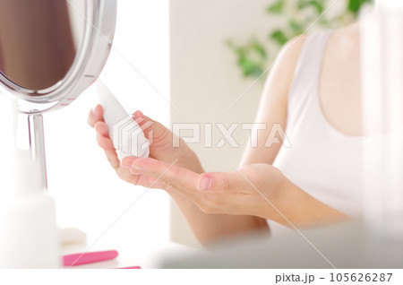 化粧品を手にとる若い女性 化粧品を手にとる若い女性 105626287