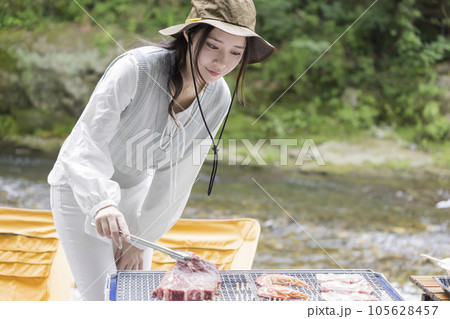 河原でバーベキューをする若い女性 河原でバーベキューをする若い女性 105628457