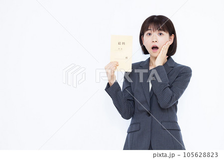 白い背景の前で給料袋を持ちびっくりしている30代の働く女性 105628823