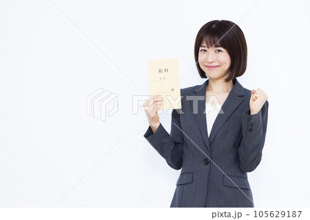 白い背景の前で給料袋を持ちガッツポーズをしている30代の女性 白い背景の前で給料袋を持ちガッツポーズをしている30代の女性 105629187