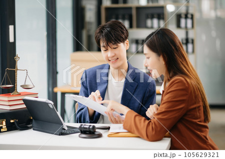 Business people compassionately holding hands and discussing contract papers with laptop and tabletat in office room. Business people compassionately holding hands and discussing contract papers with laptop and tabletat in office room. 105629321