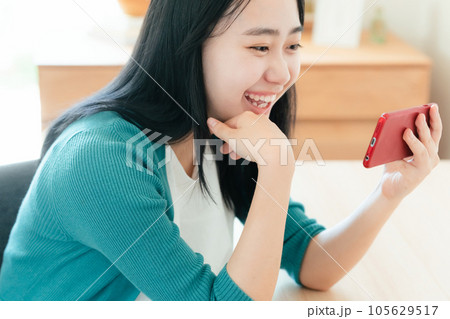 スマートフォンで動画視聴する若い女性 スマートフォンで動画視聴する若い女性 105629517