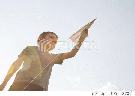 Little boy launches a paper plane into the air. Little boy launches a paper plane into the air. 105632700