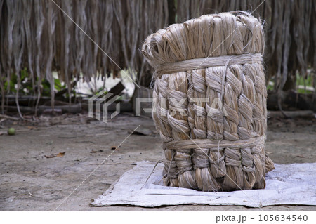 A thick brown bundle of raw jute has on the ground A thick brown bundle of raw jute has on the ground 105634540